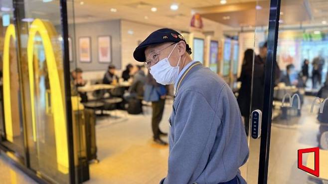 서울역의 한 패스트푸드 매장에서 '시니어 크루'로 일하고 있는 최원석씨(64)가 매장 입구에서 손님들을 맞이하고 있다. 이지예 기자