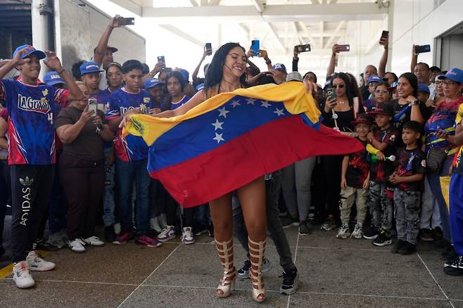 18일(현지 시간) 베네수엘라 마이케티아의 시몬 볼리바르 국제공항에서 시민들이 2026 월드베이스볼클래식(WBC) 우승컵이 도착하기를 기다리며 춤추고 있다.뉴시스