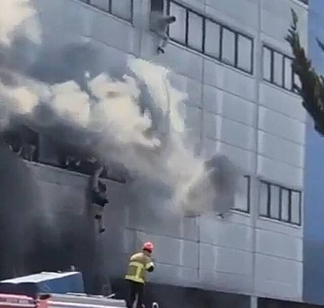 불난 공장 건물 외벽에 매달려 있는 근로자들 .연합뉴스