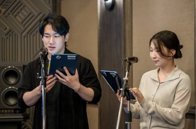 민승우(왼쪽) 성우와 신나리 성우가 지난해 여름 서울 마포구 상암 픽셀로직코리아 스튜디오에서 넷플릭스 ‘케이팝 데몬 헌터스’ 더빙을 시연하는 모습.  [넷플릭스 제공]