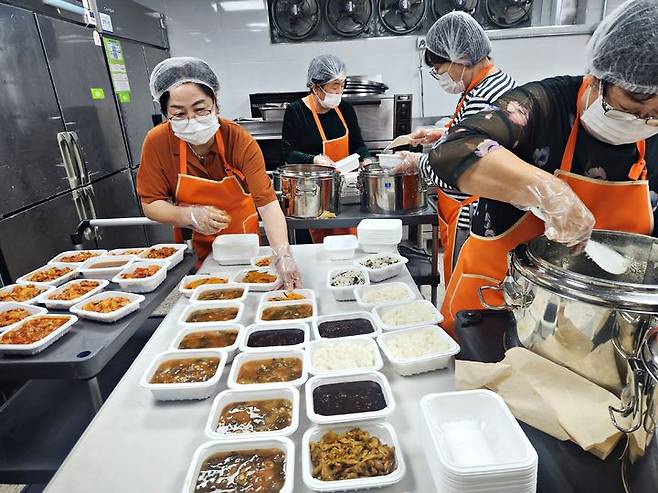 [수원=뉴시스] 자원봉사자들이 학교급식에서 나온 잔식을 위생적으로 소분해 도시락 형태로 포장하고 있다. (사진=수원시 제공) 2026.03.20. photo@newsis.com *재판매 및 DB 금지