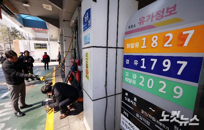 석유 최고가격제 시행 첫날인 13일 서울 마포구 한 주유소에서 한국석유관리원 관계자들이 정량기준탱크를 통해 휘발유 정량 확인을 하고 있다. 황진환 기자