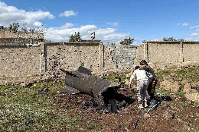 시리아에서 아이들이 지난 1일 이스라엘군에 격추·낙하한 이란 미사일 잔해를 보고 있다. AFP연합뉴스