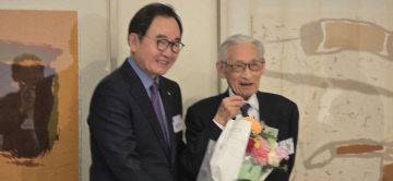 윤은기 회장이 조완규 명예회장에게 꽃다발을 전달하고 있다.