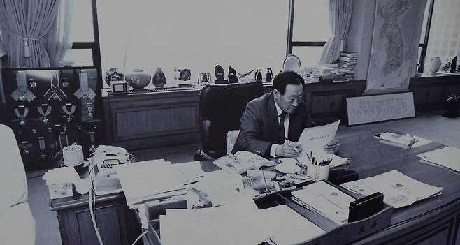 집무실에서 보고서를 검토하는 정주영 회장. 뒤에 대한민국 전도가 걸려있다.&nbsp; 김명호 편저 《건설자 정주영》 (삼련서점 서울) 108쪽.