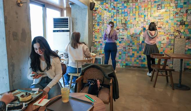 16일 오후 서울 강남구 논현동에 있는 카페 ‘휴가’에서 BTS 팬들이 카페를 내부를 둘러보고 있다. 과거 BTS 멤버 숙소였던 3층 건물을 개조해 2022년 문을 연 카페다. 보랏빛을 띤 음료 ‘퍼플그린에이드’가 대표 메뉴다. 보라색은 BTS 팬클럽 ‘아미’의 상징색이다. /박성원 기자