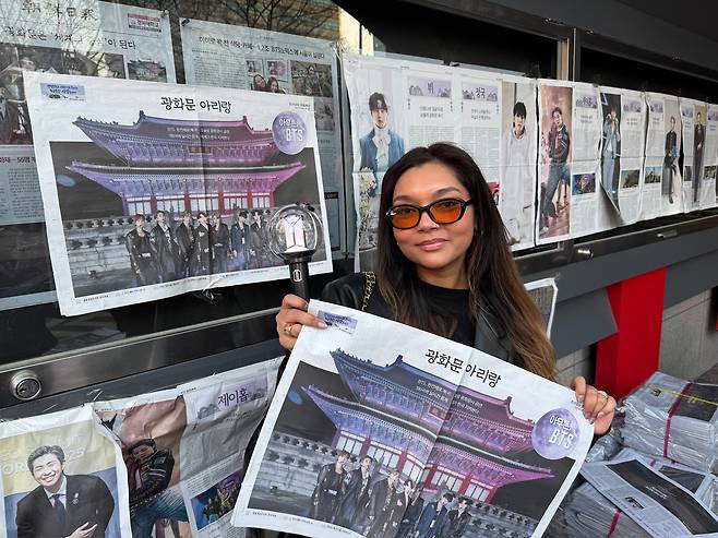 21일 광화문 BTS 컴백쇼를 앞두고 본지 호외와 응원봉을 들고 포즈를 취한 수리남 출신 앰버리엔 말리하 피어칸(33)씨. /구아모 기자