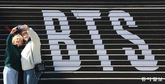 BTS컴백 공연을 일주일여 앞둔 13일 서울 종로구 광화문 세종문화회관 계단에 새겨진 BTS로고 앞에서 관광객들이 사진을 찍고있다. 김재명 기자 base@donga.com