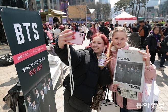 21일 서울 종로구 동아미디어센터 앞에서 BTS 팬들이 본보 BTS 특별판 신문을 들고 인증샷을 찍고 있다. 박형기 기자 oneshot@donga.com