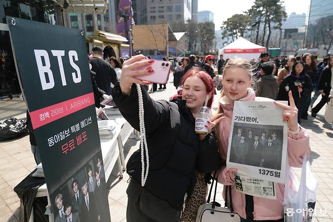 BTS 광화문 공연이 예정된 21일 오전 서울 종로구 동아미디어센터 앞에서 BTS 팬들이 동아일보 BTS 특별판 신문을 들고 환하게 웃고 있다. 박형기 기자 oneshot@donga.com