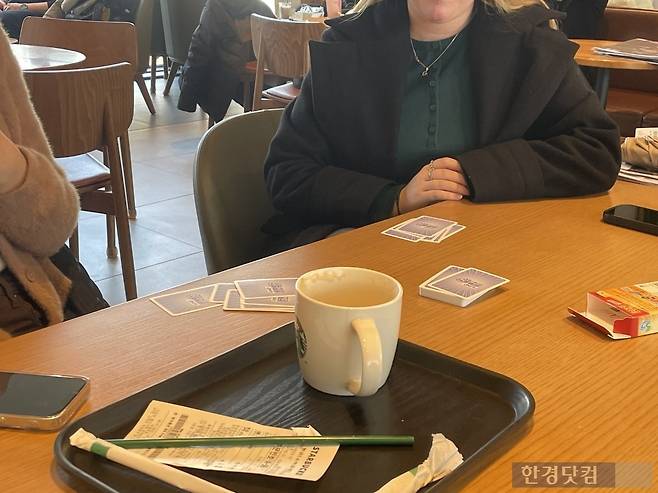 21일 오전 10시경 서울시 종로구 세종문화회관 인근 프랜차이즈 카페에서 우크라이나에서 온 20대 여성 B씨가 12시간에 이르는 대기시간을 견디기 위해 카드게임을 챙겨왔다. /사진=박상경 기자