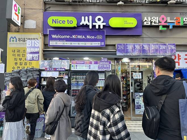 광화문 근처 편의점은 각종 생필품부터 식품류, BTS 굿즈까지 다양한 상품을 외부 매대에 배치해 관광객의 이목을 끌었다. 매장을 보라색으로 꾸민 모습도 눈에 띈다. (이채원 기자)