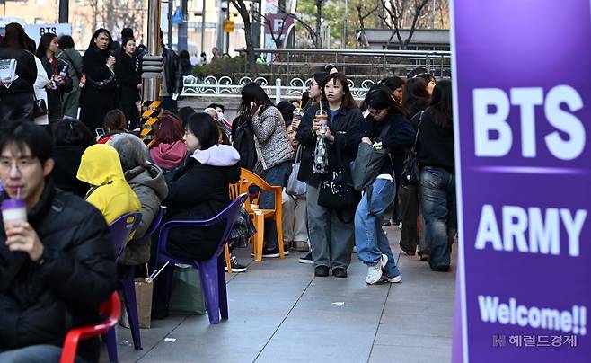 21일 서울 광화문 광장에서 그룹 방탄소년단(BTS)의  ‘BTS 컴백 라이브: 아리랑’(BTS THE COMEBACK LIVE | ARIRANG)  무료 복귀 공연이 예정된 가운데 외국인 팬들이 BTS멤버인 뷔가 광고하는 한 커피매장에 줄을 서 있다. 방탄소년단은 이날 공연에서 1시간에 걸쳐 신곡과 히트곡을 들려줄 예정이다. 이상섭 기자