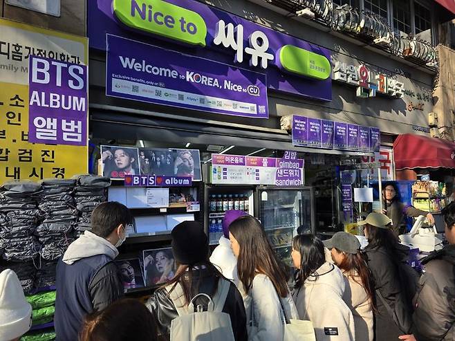 [서울=뉴시스] 김상윤 기자 = 21일 오후 광화문 인근 CU에서 고객들이 BTS 앨범과 음료를 살펴보고 있다.. 2026.03.21.&nbsp;kimsy@newsis.com.&nbsp; *재판매 및 DB 금지 *재판매 및 DB 금지