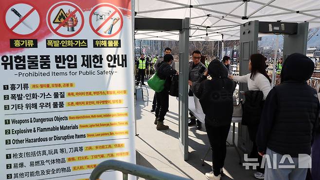 [서울=뉴시스] 조성우 기자 = 방탄소년단(BTS) 컴백 공연 당일인 21일 서울 종로구 광화문광장에서 팬들이 입장하며 검색대를 지나고 있다. 2026.03.21. xconfind@newsis.com