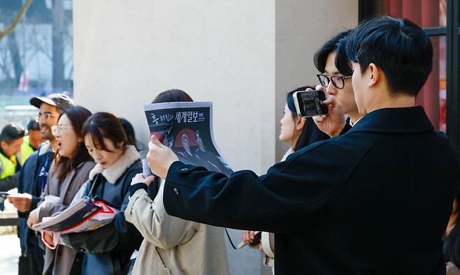 방탄소년단(BTS) 광화문 컴백 공연이 펼쳐지는 21일 서울 종로구 광화문 광장에서 한 시민이 세계일보 특별판 지면을 촬영하고 있다.