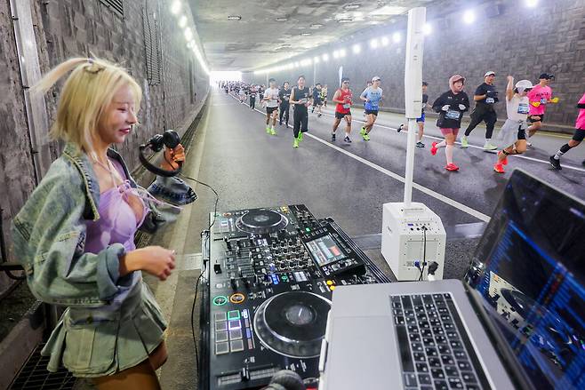 ▲&nbsp;22일 오전 인천 문학경기장에서 열린 제26회 인천국제하프마라톤대회 선학 지하차도 코스에서 마라토너들을 위한 디제잉 쇼가 진행되고 있다./전광현 기자 maggie@incheonilbo.com