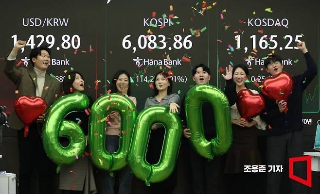 코스피가 사상 처음으로 6000선을 돌파하며 장을 마감한 25일 서울 중구 하나은행 본점 딜링룸에서 직원들이 축하 세레머니를 하고 있다. 이날 코스피 지수는 전장 대비 114.22포인트(1.91%) 오른 6083.86으로 장을 마쳤다. 2026.2.25 조용준 기자