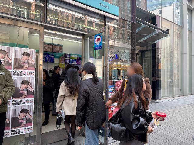 방탄소년단이 4년 만에 완전체를 이뤄 공연한 21일 서울 광화문광장 인근 GS25 매장에 팬들이 공연에 앞서 필요한 물품을 사기 위해 들어서고 있다. GS리테일 제공