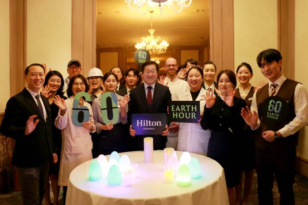 힐튼호텔경주는 오는 28일 진행되는 글로벌 환경 캠페인 '어스아워 2026'에 맞춰 오후 8시30분부터 60분 동안 로비라운지 '신라코트'의 조도를 단계적으로 낮추고 비필수 조명을 소등해 에너지 사용을 최소화하는 소등을 위해 김남철 부사장(가운데)과 임직원들이 실천의지를 다지는 퍼포먼스를 하고 있다. 힐튼경주 제공