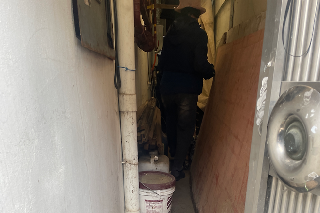 쌓아둔 짐들 사이를 피해 구석에 위치한 가스보일러에서 검침원이 점검을 하고 있다. 윤정혜기자
