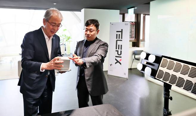 우리금융그룹 임종룡 회장(왼쪽)이 23일 서울 여의도 텔레픽스 본사에서 조성익 대표(오른쪽)에게 제품 설명을 듣고 있다. 우리금융 제공