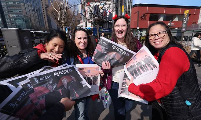 방탄소년단(BTS) 컴백 공연이 열린 지난 21일 외국인 관광객들이 서울 을지로입구역에서 세계일보가 발행한 BTS 특별판을 들어보 이며 활짝 웃고 있다. 뉴스1