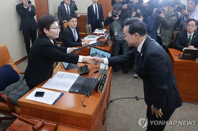 악수하는 임이자 위원장과 박홍근 후보자 (서울=연합뉴스) 신현우 기자 = 박홍근 기획예산처 장관 후보자가 23일 국회 재정경제기획위원회에서 열린 인사청문회에서 선서를 마친 뒤 임이자 위원장에게 선서문을 전달 후 악수하고 있다. 2026.3.23 nowwego@yna.co.kr