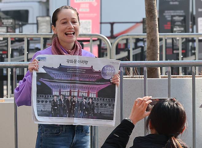 방탄소년단(BTS)의 컴백 공연이 열린 21일 서울 광화문 광장 일대에서 주요 신문사들이 낸 호외·특별판을 받아 든 팬들이 기념 촬영을 하고, 내용을 살펴보고 있다. /연합뉴스