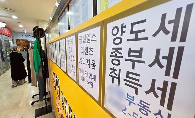 서울 시내 한 공인중개사 사무실 외벽에 부동산 관련 세금과 아파트 매매 물건 등의 안내문이 게시되어 있다. / 사진=연합뉴스