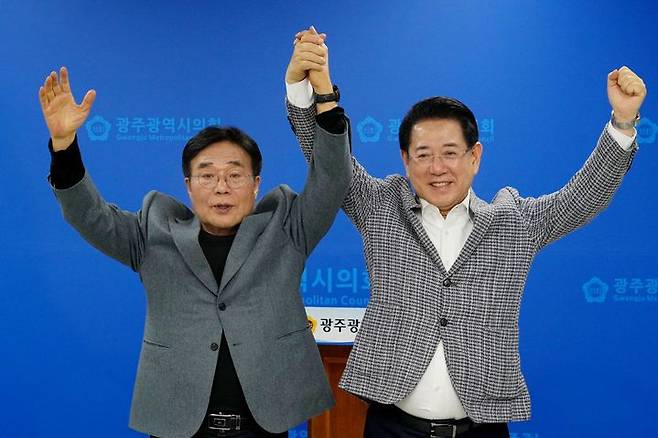 전남광주특별시장 더불어민주당 경선주자인 김영록 후보 캠프 총괄상임선거대책위원장으로 합류한 이병훈 민주당 호남발전특위 수석부위원장(왼쪽)과 김 후보가 24일 광주시의회 브리핑룸에서 원팀 구성에 합의한 뒤 두 손을 번쩍 들어 보이고 있다. 뉴시스