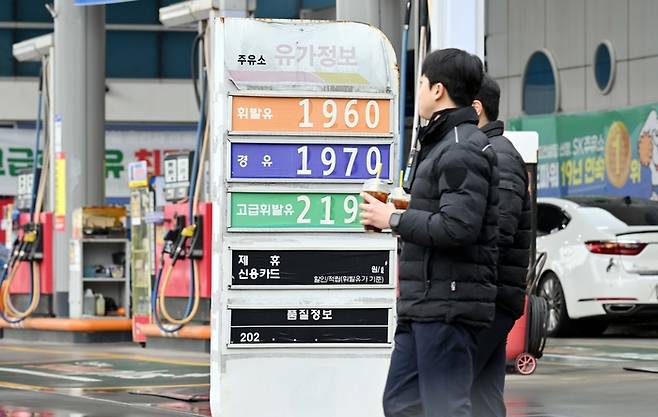 시민들이 서울 시내 주유소에 세워져 있는 가격표 앞을 지나고 있다. [김재훈 기자]