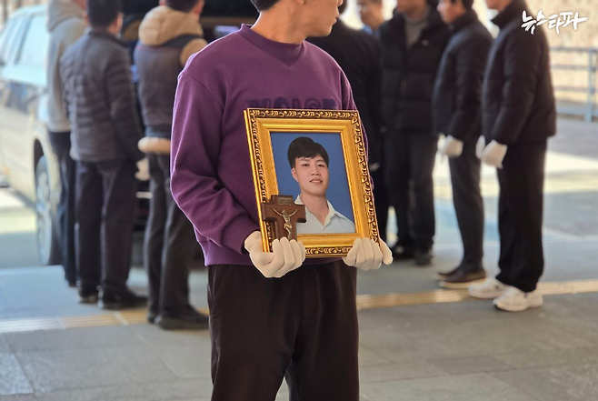 지난 19일, 뚜안 씨의 화장이 진행되는 경기도 용인 평온의 숲에서 친구 깐 씨가 뚜안 씨의 영정사진을 들고 있다.