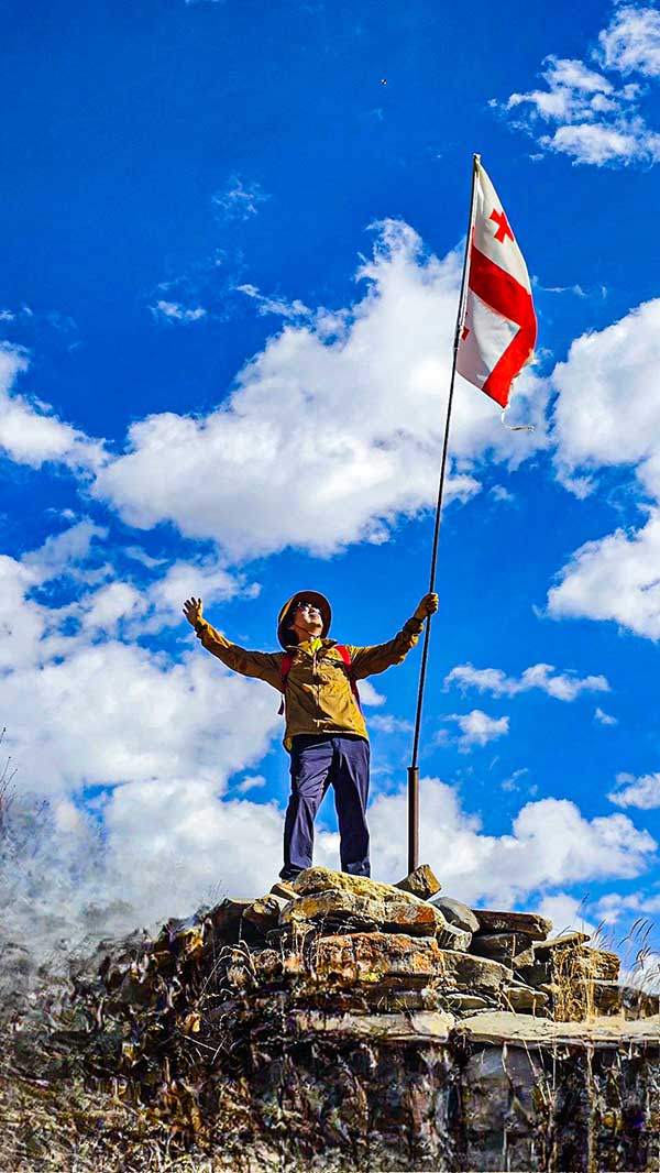 산마루 돌탑 위에 조지아 국기가 펄럭인다.