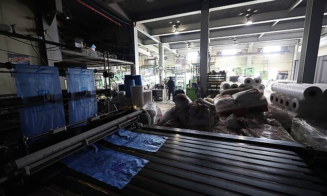 24일 중동 사태에 따른 폴리에틸렌 등 원료 수급 불안 영향으로 최근 일시적으로 인원 감축 운영에 들어간 경기 안산시의 한 비닐봉투, 종량제 봉투 제조 공장 내 가공 작업대의 불이 꺼져있다. 연합뉴스