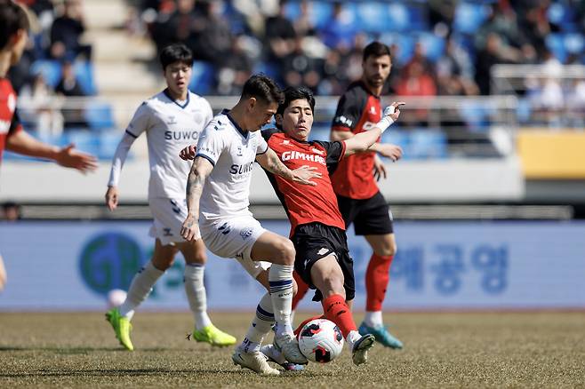 김해FC 문승민(빨간 유니폼)이 지난 14일 수원FC와의 홈경기에서 윌리안의 볼을 빼앗으려 하고 있다. 프로축구연맹 제공