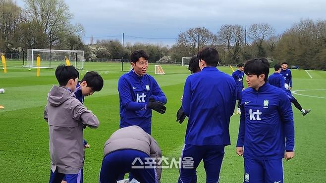 축구대표팀 캡틴 손흥민이 25일 새벽(한국시간) 영국 밀턴 케인즈에 있는 에메르송 밸리 풋볼클럽에서 진행된 3월 A매치 소집 첫 훈련에 앞서 김민재 등 동료와 얘기하고 있다. 사진 | 밀턴 케인즈=김용일 기자
