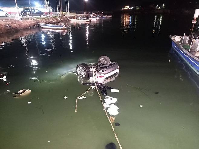 지난 24일 오후 7시19분쯤 부산 기장군 죽성항에서 40대 엄마와 10대 자녀 2명이 탑승한 SUV가 바다에 빠져 소방이 구조하고 있다. 이 사고로 엄마가 숨졌다. 사진 부산소방재난본부