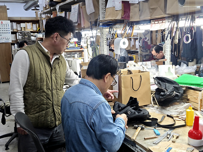 이경한 강남사 대표가 직원이 수선하는 모습을 가리키고 있다. [김혜진 기자]