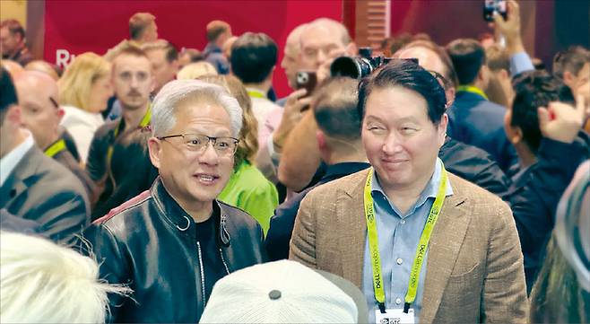 지난 3월 16일(현지 시간) 미국 캘리포니아주 새너제이에서 개막한 엔비디아의 연례 개발자 콘퍼런스 ‘GTC 2026’에서 젠슨 황 엔비디아 CEO(왼쪽)와 최태원 SK그룹 회장이 함께 SK하이닉스 부스를 돌아보고 있다. (SK하이닉스 제공)