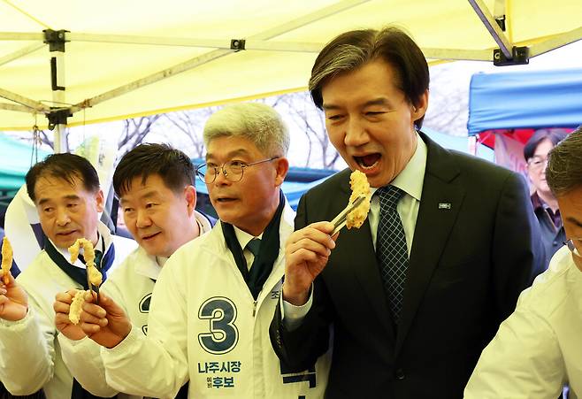 조국 조국혁신당 대표(왼쪽 네 번째)가 25일 오전 전남 나주시 영산포풍물시장에서 튀김을 먹고 있다. ⓒ연합뉴스