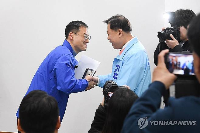 악수하는 김상욱과 김종훈 (울산=연합뉴스) 25일 울산시의회 프레스센터에서 더불어민주당 김상욱 의원(왼쪽)과 진보당 김종훈 전 동구청장이 우연히 만나 악수하고 있다. 6ㆍ3 지방선거에서 울산시장 후보로 출마하는 이들은 범진보 진영 후보 단일화 작업을 진행할 것으로 예상된다. 2026.3.25 [울산시의회 제공. 재판매 및 DB 금지] hkm@yna.co.kr