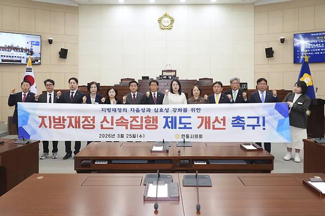 안동시의회 김새롬 의원을 비롯한 의원들이 ‘지방재정 신속집행 ’ 제도 개선을 촉구하는 현수막 뒤에서 기념사진을 찍고 있다./안동시의회 제공