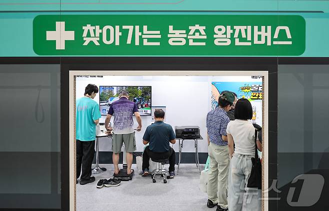 서울 서초구 aT센터에서 열린 '2024 대한민국 농업박람회'에서 관람객이 찾아가는 농촌 왕진버스를 살펴보고 있다. ⓒ 뉴스1 김도우 기자