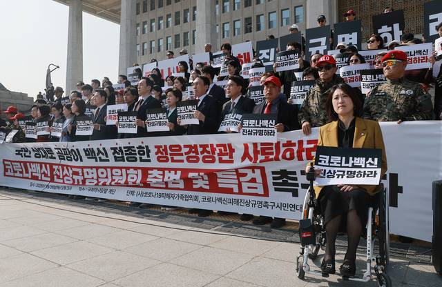 장동혁 국민의힘 대표가 26일 국회 본청 앞 계단에서 코로나19피해자가족협의회, 코로나백신피해진상규명촉구시민연대가 연 코로나백신 진상규명위원회 출범 촉구 기자회견에 참석해 손팻말을 들고 있다. [연합뉴스]