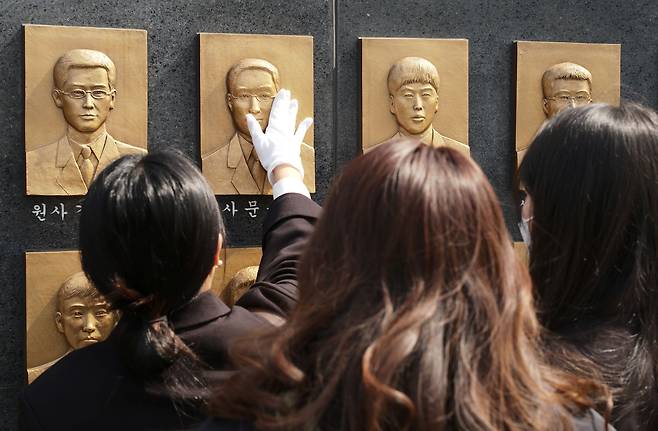천안함 유가족들이 추모비를 어루만지고 있다.