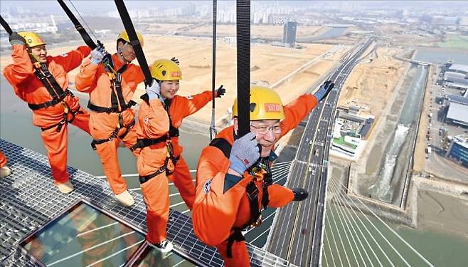 청라하늘대교 주탑 상판에 설치된 엣지워크 체험시설에서 인천시와 인천경제청 관계자들이 25일 시범 체험을 보이고 있다. /인천경제자유구역청 제공
