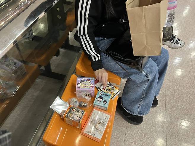 [서울=뉴시스] 김수빈 인턴기자= 26일 오후 3시께 20대 프리랜서 A씨가 국제전자센터에서 구매한 피규어, 카드 등 굿즈를 꺼내 보여주고 있다. 2026.03.25. *재판매 및 DB 금지