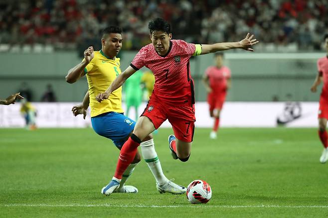 축구대표팀 손흥민이 2022년 6월 평가전에서 브라질 카세미루를 제치고 드리블하고 있다. Getty Images코리아