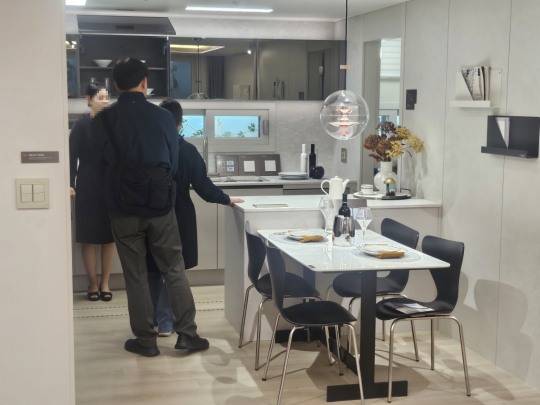 59㎡A타입 주방에서 유상옵션과 구조를 꼼꼼하게 확인하는 방문객들./한국금융신문 조범형 기자